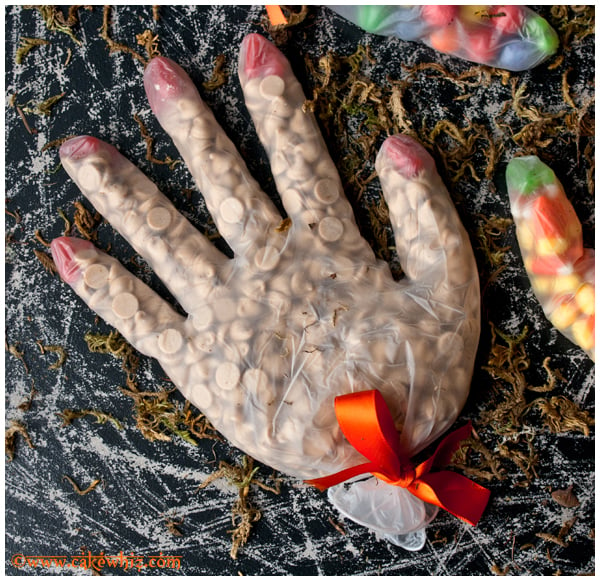 Spooky Candy Goodie Bags in Gloves on Rustic Black Background