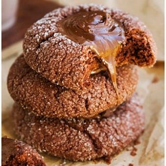 Stack of Easy Classic Chocolate Thumbprint Cookies on Brown Paper.