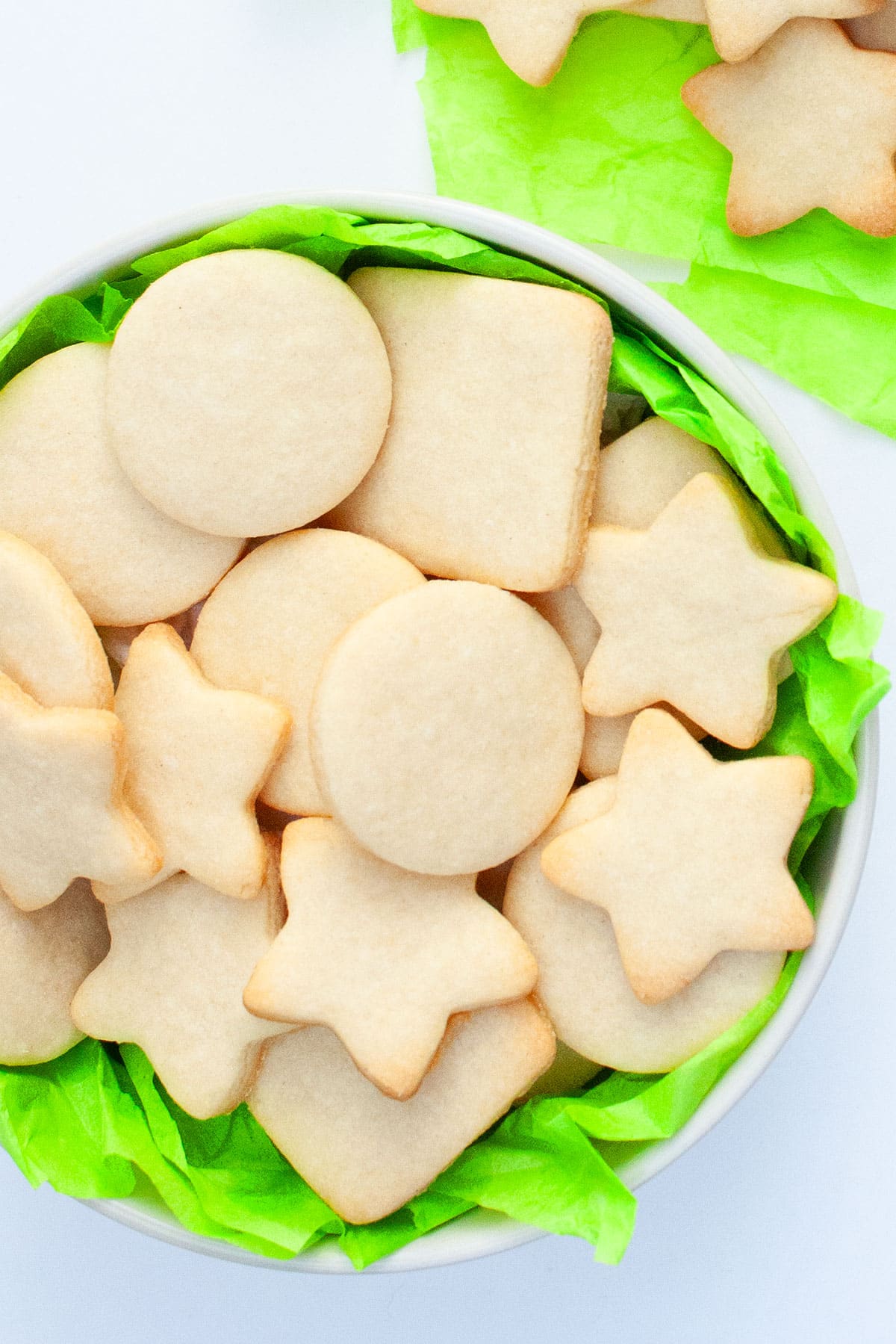 Easy Small Batch of Cut Out Sugar Cookies in White Dish With Green Tissue Paper. 