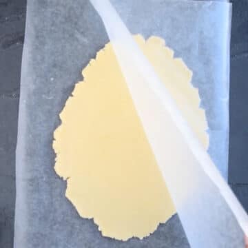 Top sheet being removed from flattened dough. 