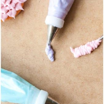 Piping Bags of Easy Royal Icing For Cookie Decorating on Light Brown Background.