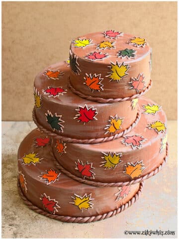 Tiered Round Abstract Cake With Leaf Stamps on Rustic Brown Background.