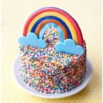 Easy Rainbow Sprinkle Cake on White Plate with Yellow Background