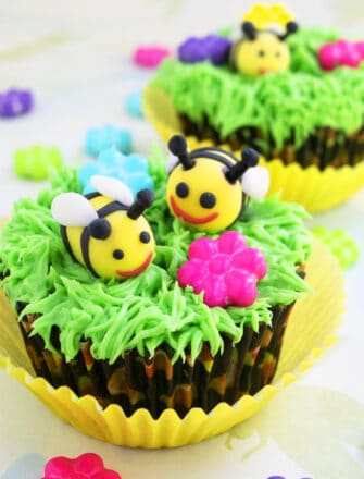 Easy Fondant Bee Cupcakes (Honey Bee or Bumblebee) With Green Grass Icing on Light Yellow Background