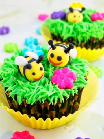 Easy Fondant Bee Cupcakes (Honey Bee or Bumblebee) With Green Grass Icing on Light Yellow Background