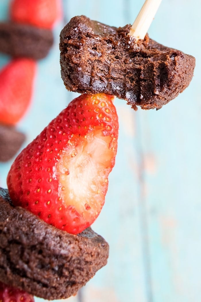 Partially Eaten Fruit Skewers With Strawberries and Chocolate Brownies