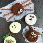 Easy Halloween Donuts (Mummy, Spider, Bat, Cat, Ghost, Monster) on Metallic Gray Background With Chocolate Sprinkles.