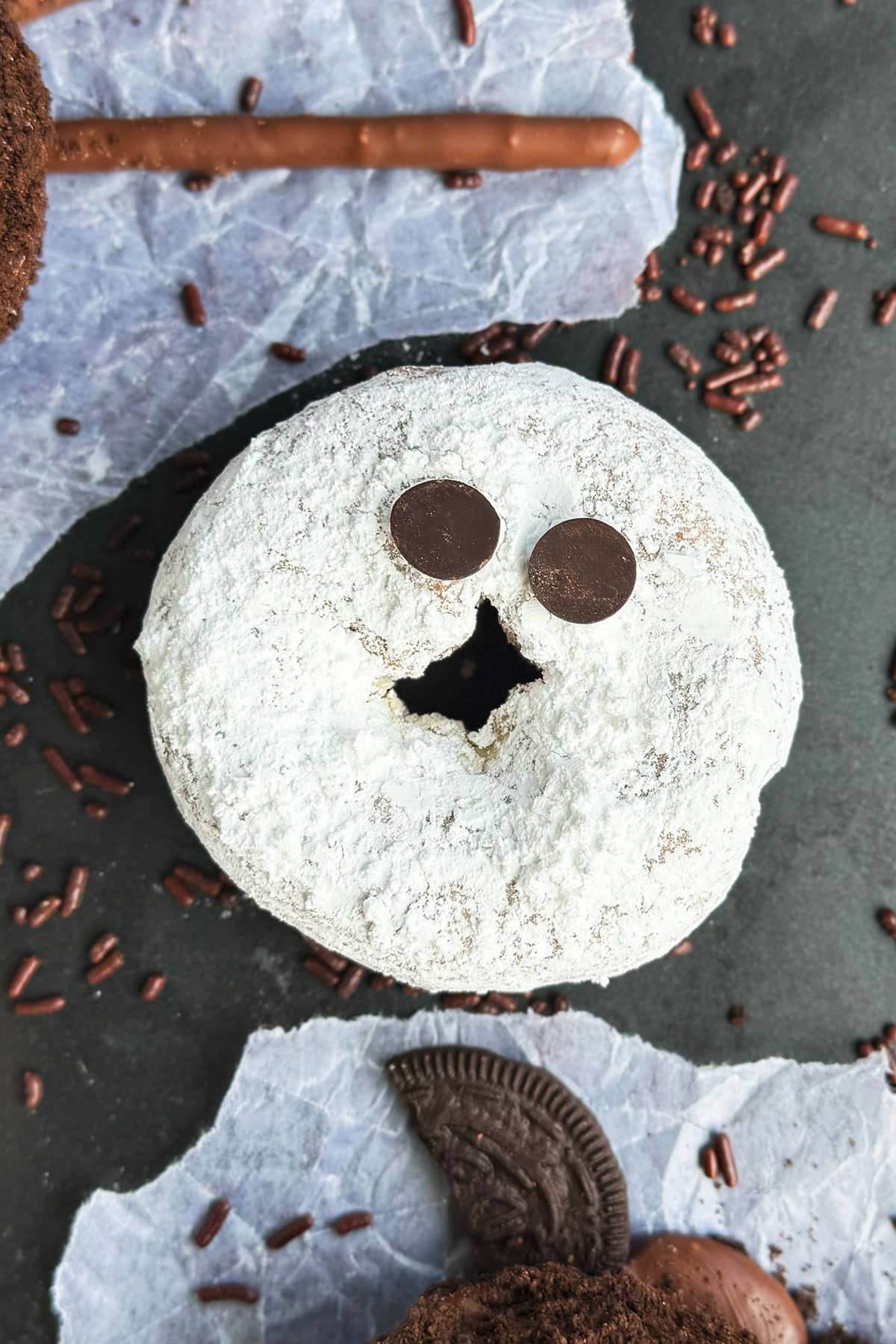 Easy homemade ghost donuts on metallic gray background. 