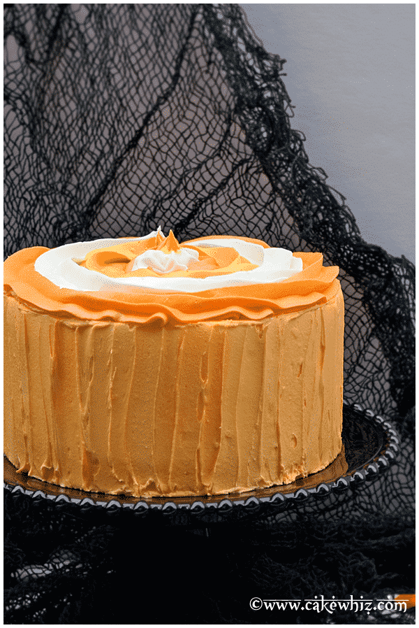 Halloween Cake Decorated With Orange, Yellow, White Buttercream Icing on Black Cake Stand 