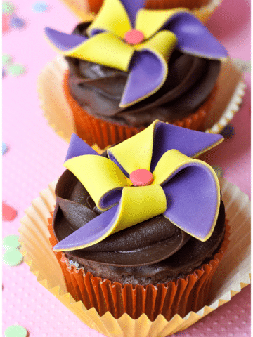 Purple and Yellow Pinwheel Cupcake Toppers on Frosted Cupcakes.