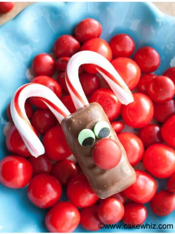 Rudolf Chocolate Bars Placed on Top of Red Candies in Blue Dish.