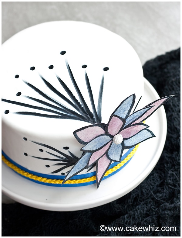Overhead Shot of White Cake Decorated with Wafer Paper and Black Edible Marker