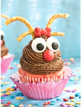 Easy Reindeer Cupcakes For Christmas With Blue Background and Sprinkles Scattered Everywhere