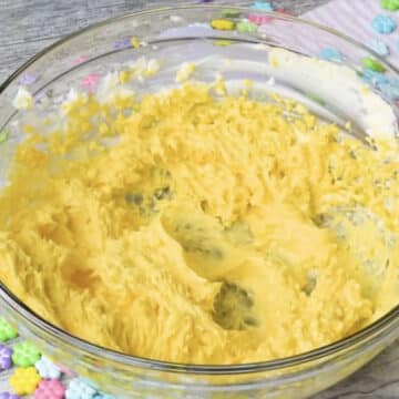 Mango puree mixed with butter mixture in glass bowl. 