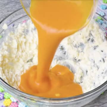 Mango puree being poured into the butter mixture. 