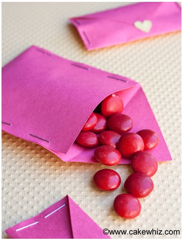 Homemade Love Letter Filled with Red Candies, Placed on Yellow Background