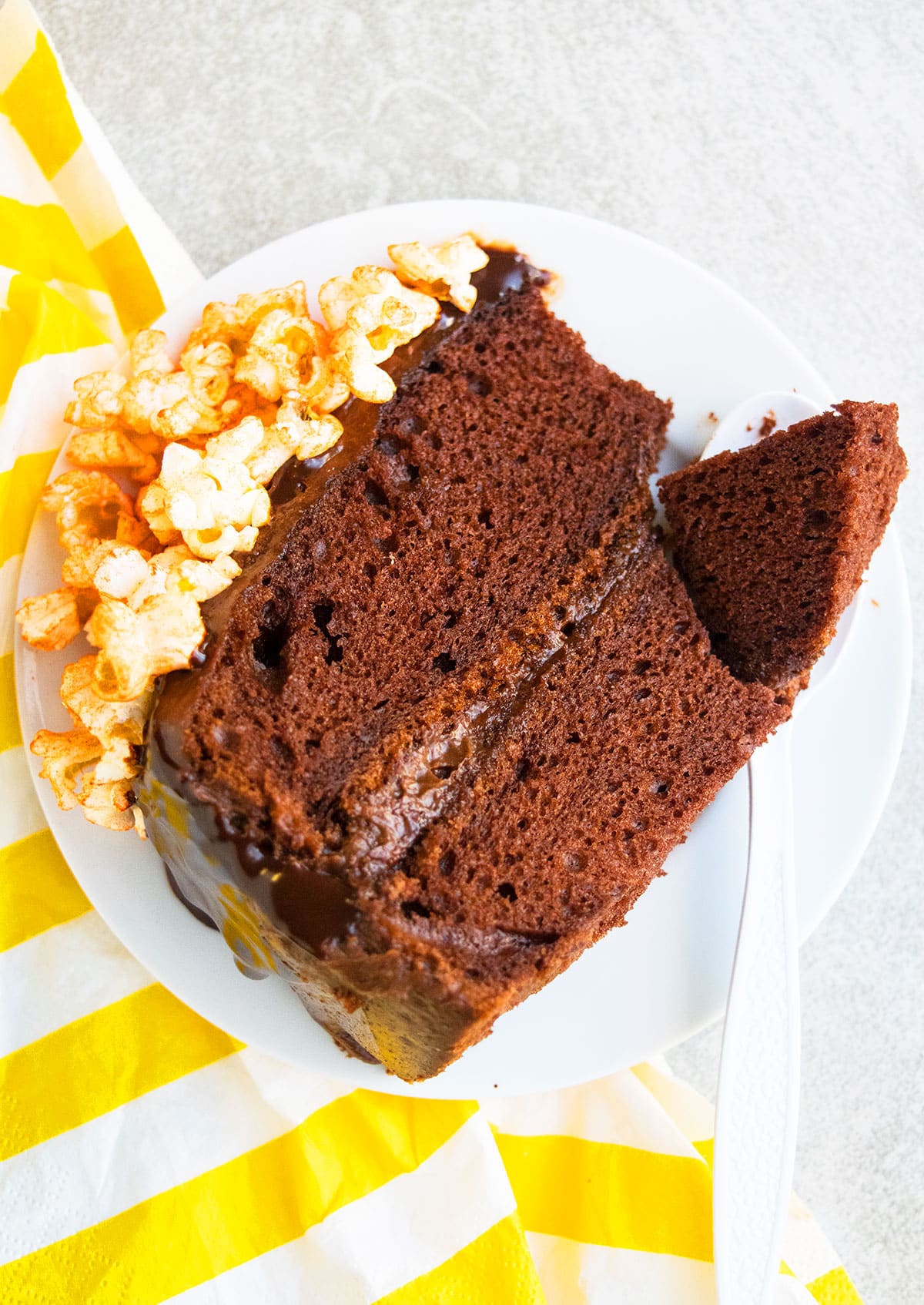 Partially eaten cake slice on white dish. 