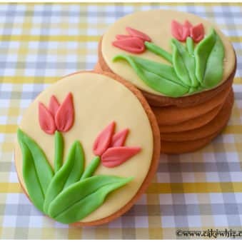 Easy Tulip Cookies Decorated With Fondant on a Gingham Yellow and Gray Background.