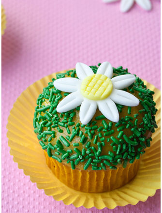 Easy Fondant Daisy Cupcakes in Yellow Cupcake Liners With Pink Background