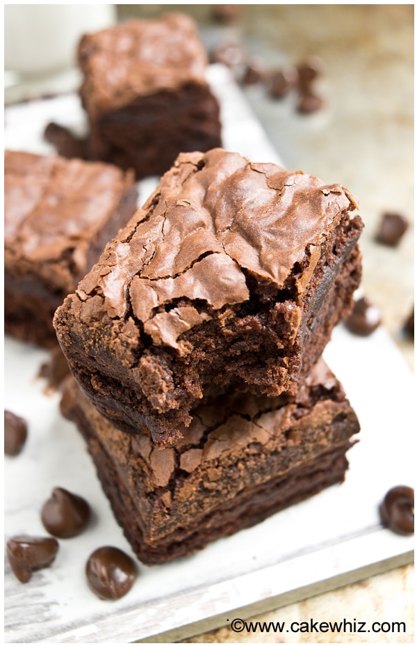 Stack of Easy Fudgy Brownies With Crackly Tops on White Dish. 