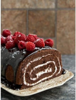 Easy Homemade Chocolate Cake Roll with Chocolate Ganache and Raspberries on Brown Tray