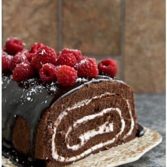 Easy Homemade Chocolate Cake Roll with Chocolate Ganache and Raspberries on Brown Tray