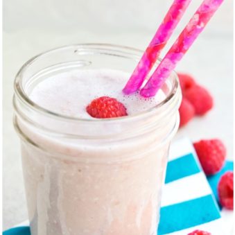 Easy Raspberry Smoothie in Glass Cup with Pink Straw on Striped Blue Napkin