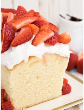 Easy Sour Cream Pound Cake With Whipped Cream and Strawberries on White Tray With Gold Rim