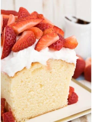 Easy Sour Cream Pound Cake With Whipped Cream and Strawberries on White Tray With Gold Rim