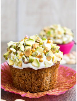 Easy Homemade Carrot Cupcakes With Cream Cheese Frosting and Pistachios on Rustic Background