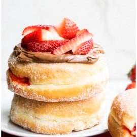 Stack of Homemade Jelly Filled Donuts (Sufganiyot) Topped with Nutella and Fresh Strawberries.