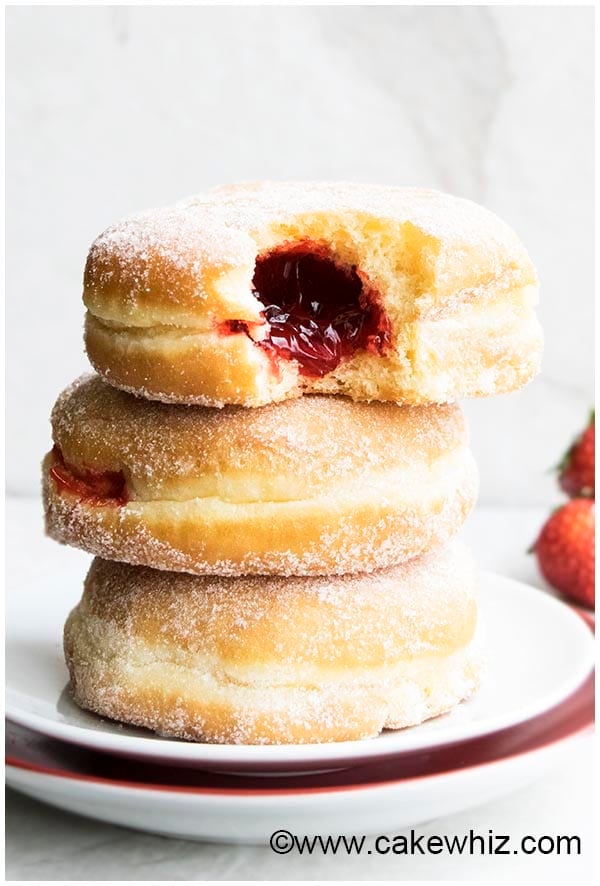 Homemade Jelly Filled Donuts Stacked on a White Dish