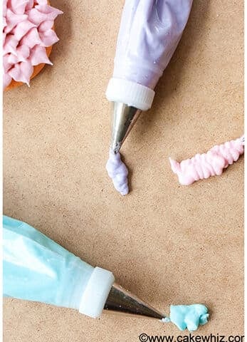 Piping Bags of Colorful Easy Royal Icing For Cookie Decorating on Light Brown Background.