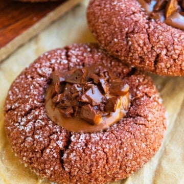 Easy Chocolate Thumbprint Cookies With Ganache Filling on Brown Parchment Paper.