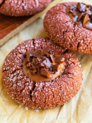 Easy Chocolate Thumbprint Cookies With Ganache Filling on Brown Parchment Paper.