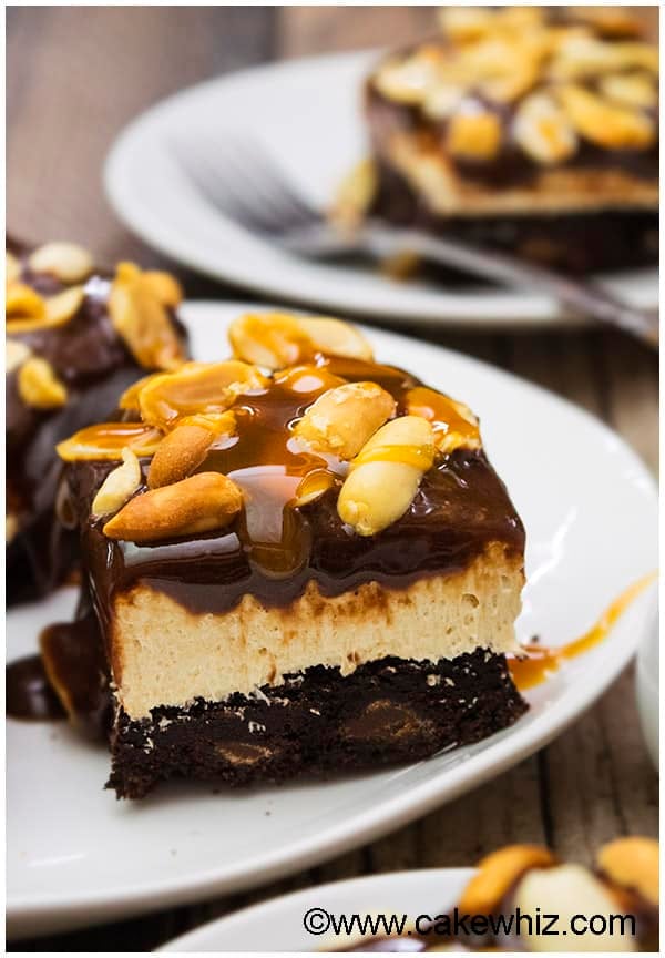 Slice of Caramel Peanut Chocolate Cheesecake Bar on White Dish- Closeup Shot