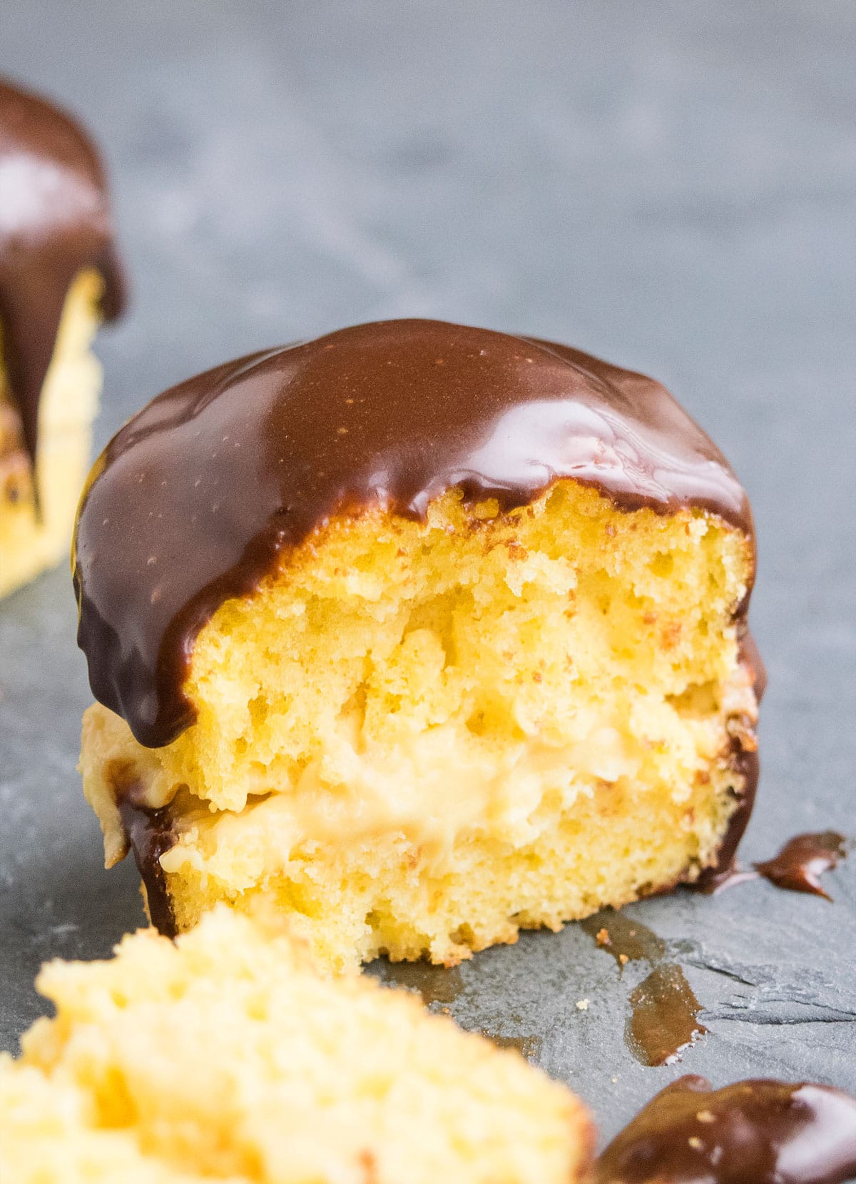 Partially Eaten Vanilla Cupcake With Pastry Cream Filling and Chocolate Ganache Topping. 