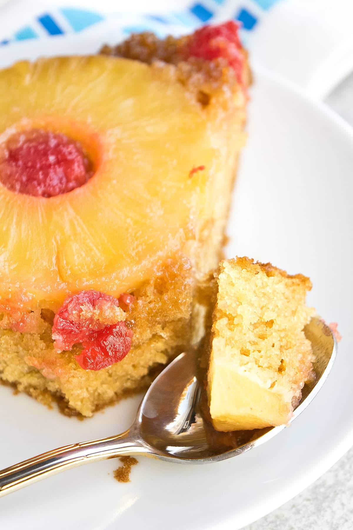 Spoonful of cake on white dish. 