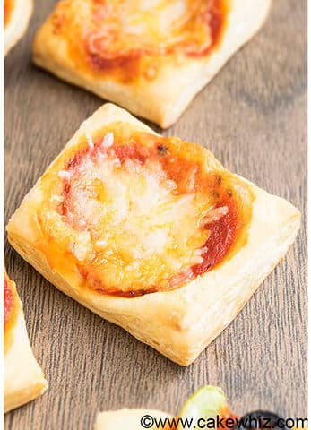 Easy Mini Puff Pastry Pizza Appetizer on Wood Background.