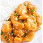 Easy Slow Cooker Orange Chicken in White Dish With Rice.