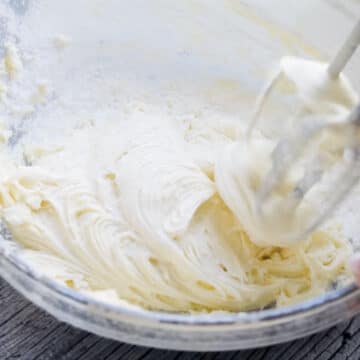 Final mixing of icing in glass bowl with hand held mixer.