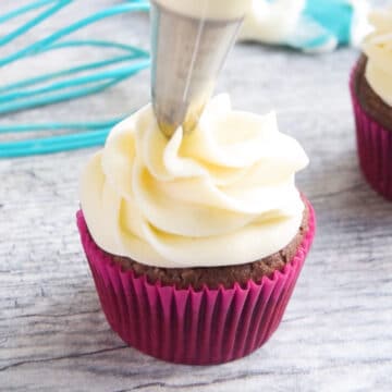 Piping a swirl on top of chocolate cupcake. 