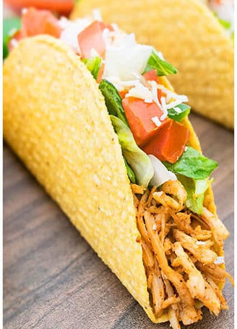 Easy Shredded Chicken Tacos on Wood Background.