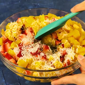 Ingredients all being mixed together with big green spoon.