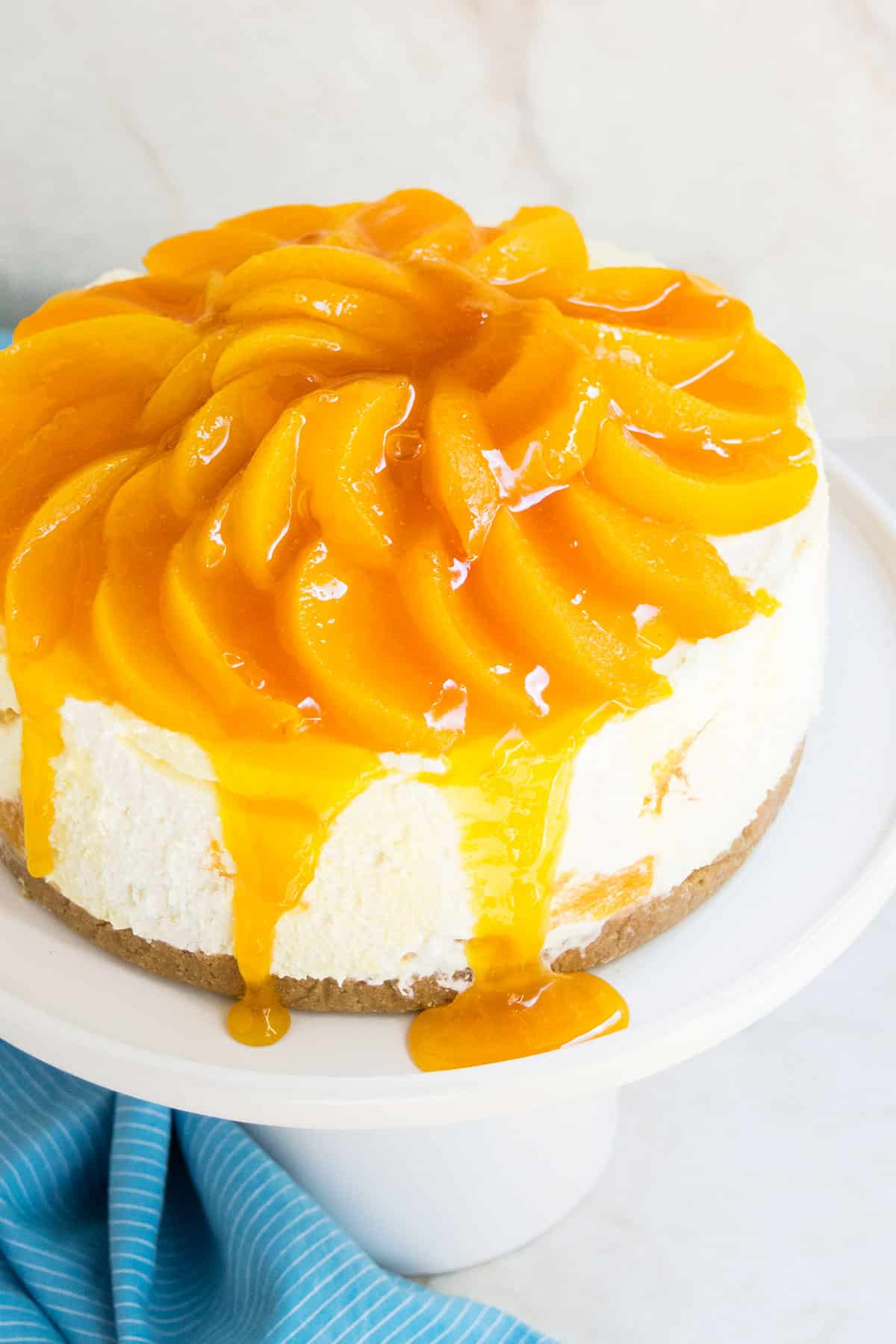 Easy No Bake Peach Cheesecake With Fresh or Canned Peaches and Graham Cracker Crust on White Cake Stand. 