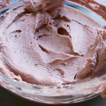 Spatula used to smooth out icing in glass bowl. 
