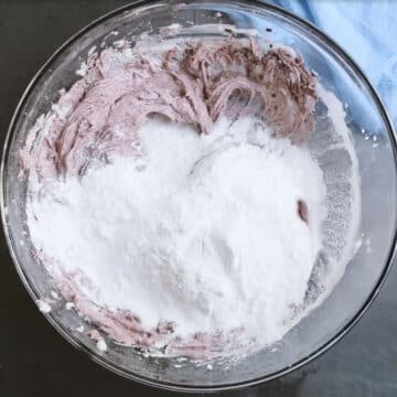 Powdered sugar added to mixture in glass bowl.