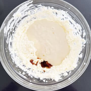 Flour mixture, vanilla extract, creamed butter and shortening in glass bowl. 