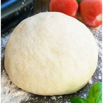 Best Easy Homemade Pizza Dough on Countertop With Flour, Tomatoes and Rolling Pin.