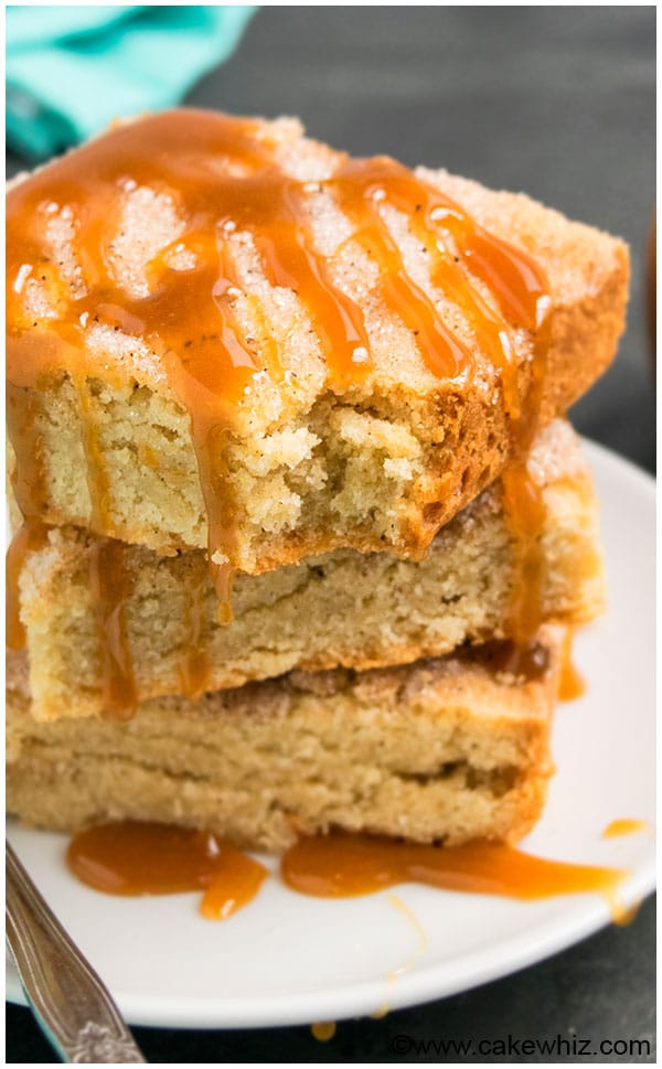 Soft and Chewy Snickerdoodle Bars Stacked on a White Plate With Drizzle of Caramel Sauce